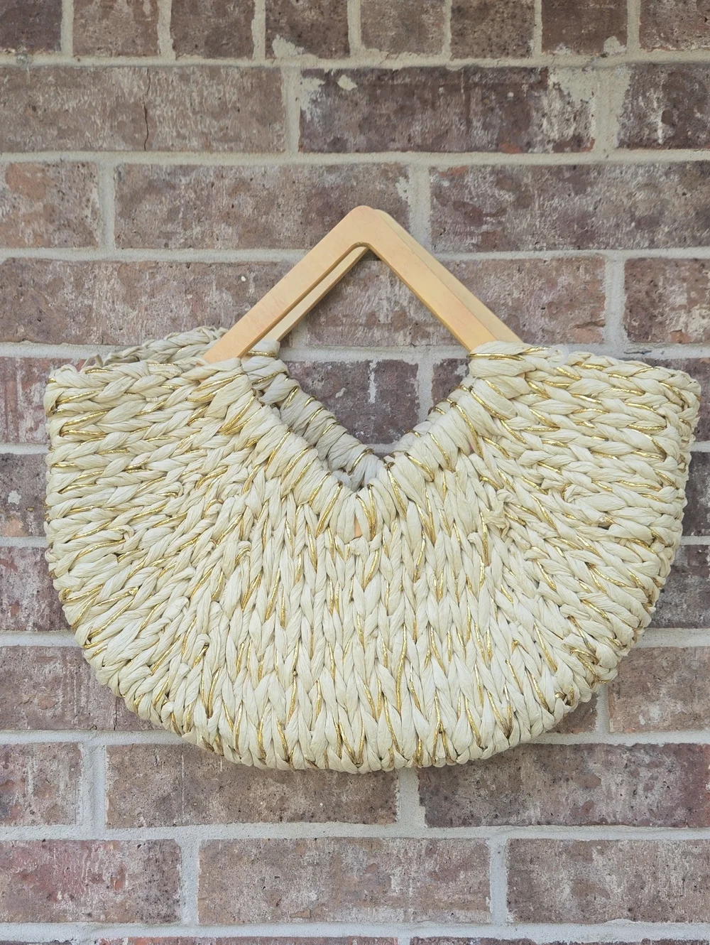 Buru Shop woven crescent straw satchel with structured geometric handles.